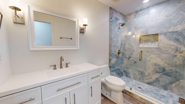 bathroom featuring hardwood / wood-style flooring, vanity, toilet, and a shower with door