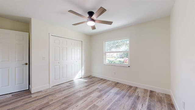 unfurnished bedroom featuring a closet, light hardwood / wood-style flooring, and ceiling fan