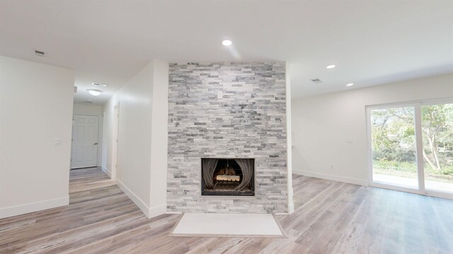 unfurnished living room with a fireplace and light hardwood / wood-style flooring