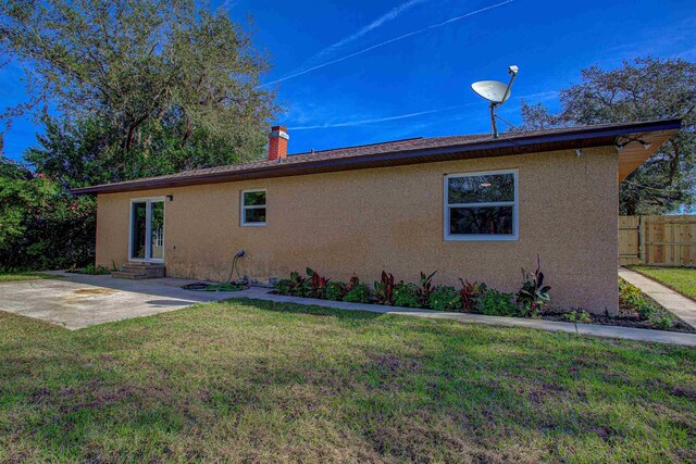 rear view of house featuring a lawn and a patio area