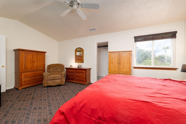 bedroom with dark colored carpet, ceiling fan, and lofted ceiling