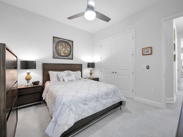 bedroom featuring ceiling fan, a closet, and light carpet