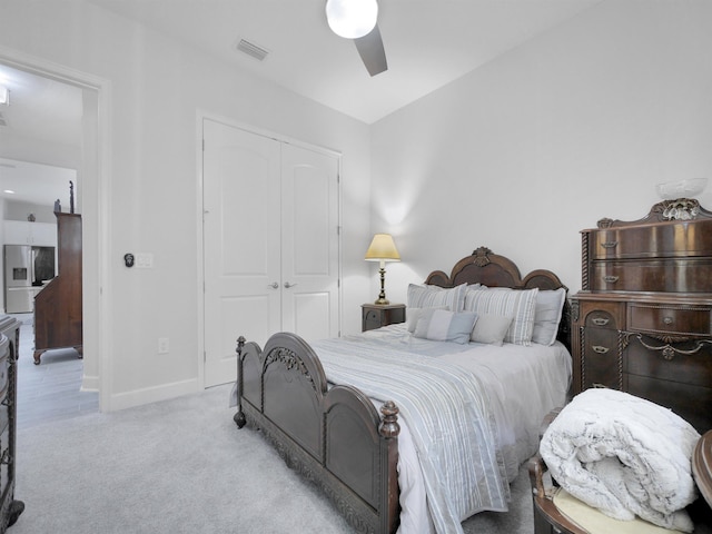 bedroom with light carpet, stainless steel fridge with ice dispenser, a closet, and ceiling fan