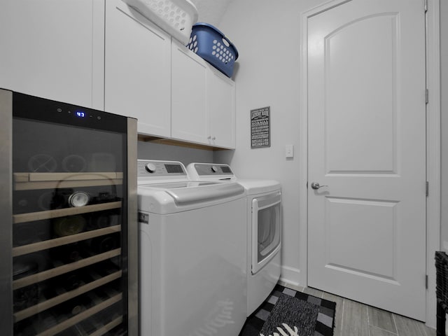 laundry room with washing machine and dryer, cabinets, and light hardwood / wood-style floors