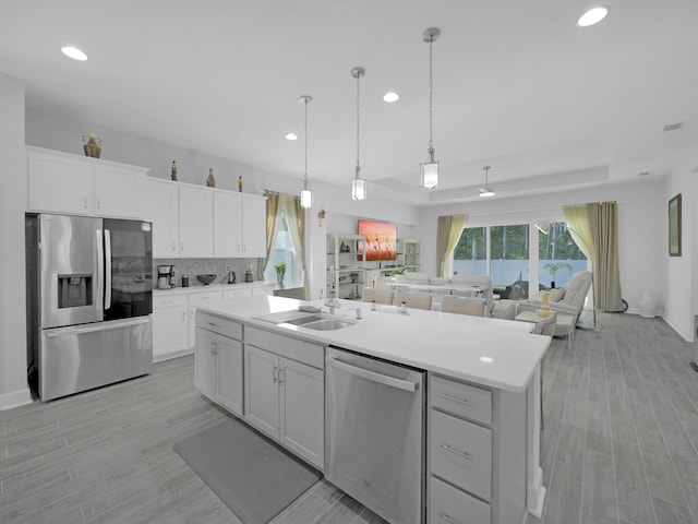 kitchen featuring sink, white cabinetry, stainless steel appliances, and a kitchen island with sink