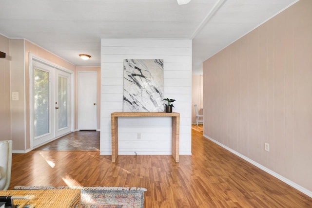 interior space featuring wood walls, wood-type flooring, and french doors