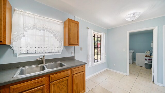 5015 Portsmouth Ave, Jacksonville, FL 32208 - kitchen with light tile patterned floors, separate washer and dryer, a sink, dark countertops, and brown cabinets