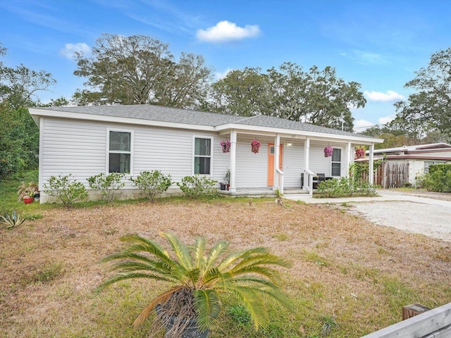 ranch-style home featuring a front yard and covered porch