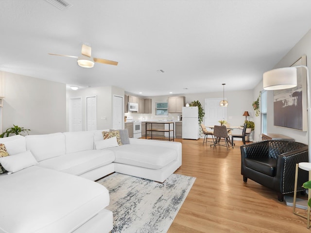 living room with ceiling fan and light wood-type flooring