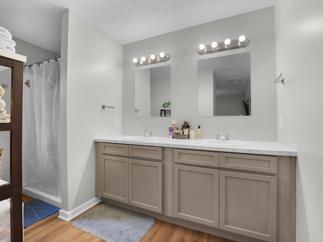 bathroom with vanity, wood-type flooring, a textured ceiling, and a shower with shower curtain