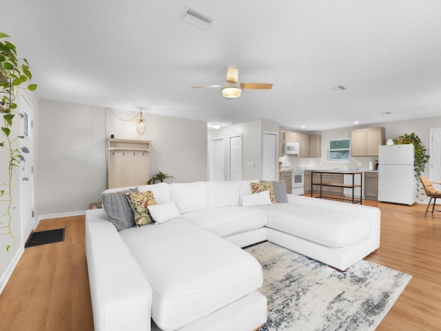 living room featuring ceiling fan and light wood-type flooring