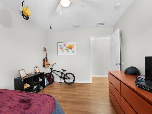 bedroom featuring ceiling fan, a textured ceiling, and light hardwood / wood-style flooring