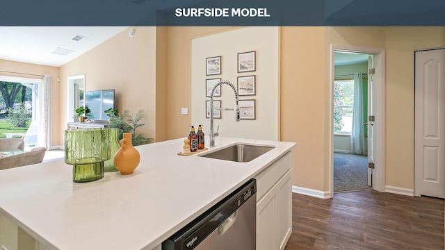 kitchen featuring dark hardwood / wood-style flooring, stainless steel dishwasher, an island with sink, lofted ceiling, and white cabinets