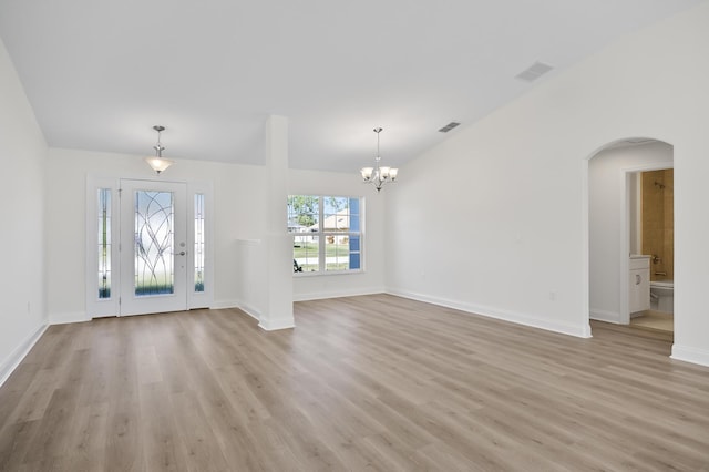 foyer entrance with light wood-type flooring and an inviting chandelier