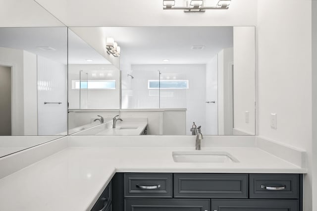 bathroom featuring a shower and vanity