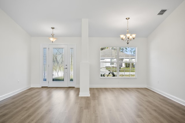 foyer entrance featuring hardwood / wood-style flooring and an inviting chandelier