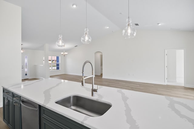 kitchen with light stone countertops, sink, pendant lighting, and vaulted ceiling