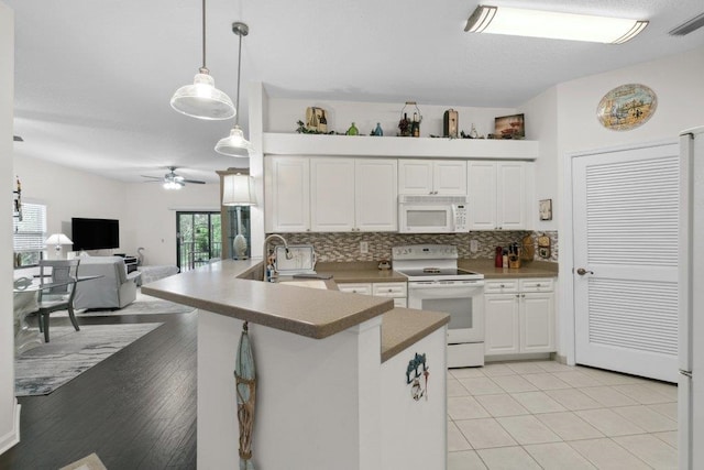 104 Laurel Wood Way Unit 202, Saint Augustine, FL 32086 - kitchen with white appliances, a peninsula, white cabinets, a ceiling fan, and tasteful backsplash