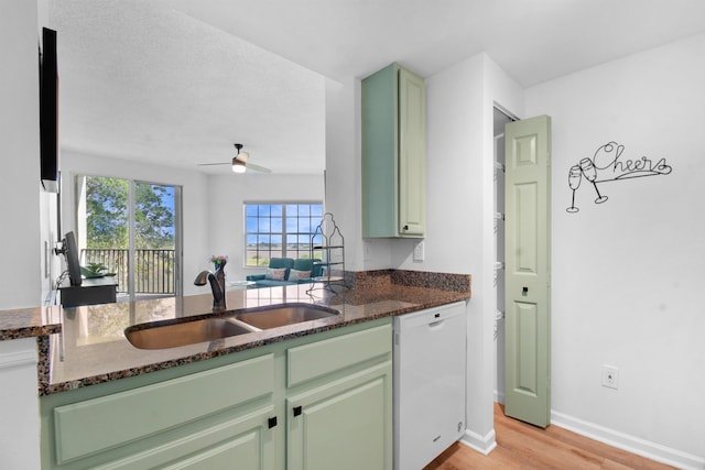 4020 Grande Vista Blvd Unit 204, Saint Augustine, FL 32084 - kitchen featuring dishwasher, green cabinetry, a sink, and dark stone countertops