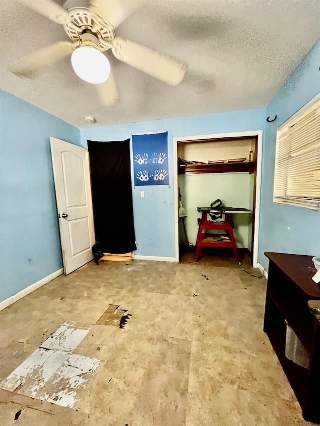 bedroom with baseboards, ceiling fan, and a textured ceiling