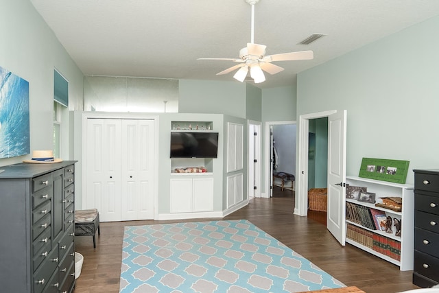 bedroom with a textured ceiling, dark hardwood / wood-style flooring, a closet, and ceiling fan