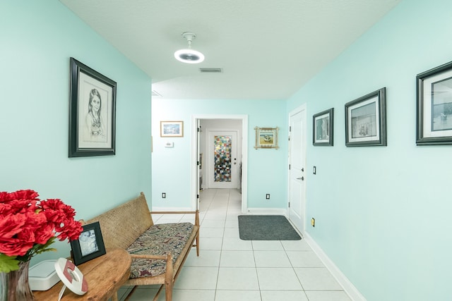 hallway featuring light tile patterned floors and a textured ceiling