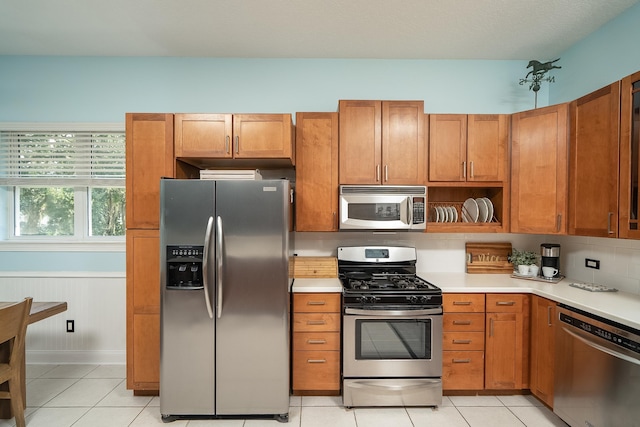 kitchen featuring appliances with stainless steel finishes, tasteful backsplash, and light tile patterned floors