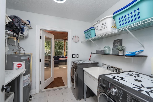 laundry room with washer and clothes dryer, sink, a textured ceiling, water heater, and light tile patterned flooring