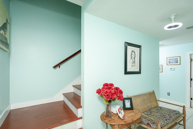 stairway featuring tile patterned flooring and a textured ceiling