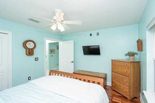 bedroom featuring ceiling fan, wood-type flooring, and a textured ceiling