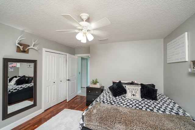 bedroom featuring ceiling fan, a closet, dark wood-type flooring, and a textured ceiling