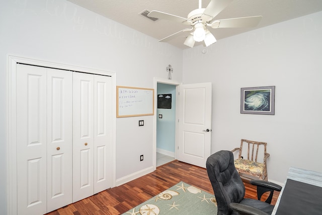 home office with a textured ceiling, ceiling fan, and dark hardwood / wood-style floors