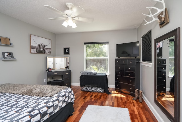 bedroom featuring ceiling fan, wood-type flooring, and a textured ceiling