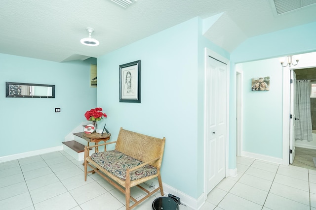 hall with light tile patterned floors and a textured ceiling