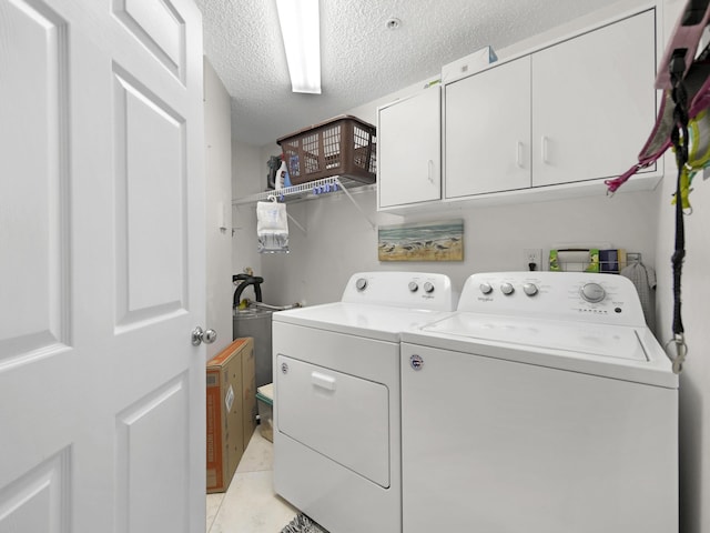 laundry area with cabinet space, a textured ceiling, and independent washer and dryer