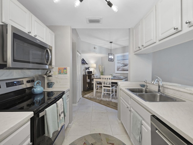kitchen with a sink, marble finish floor, white cabinets, appliances with stainless steel finishes, and visible vents
