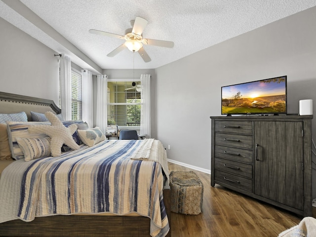 bedroom featuring ceiling fan, baseboards, wood finished floors, and a textured ceiling