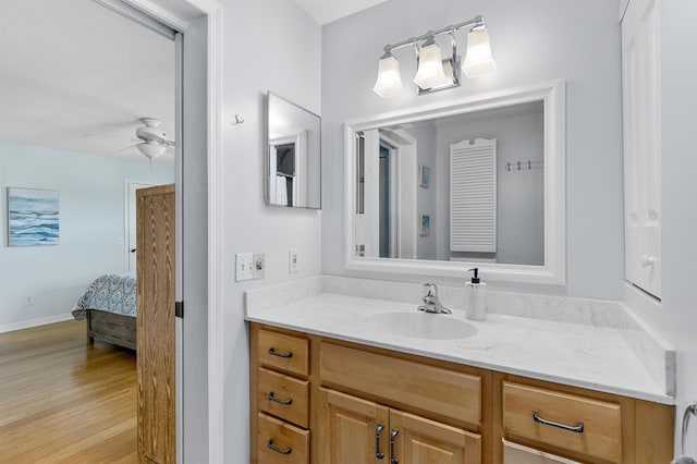 bathroom featuring ceiling fan, hardwood / wood-style floors, and vanity