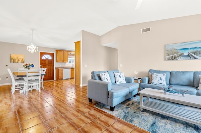 living room featuring light tile patterned floors, lofted ceiling, and a notable chandelier