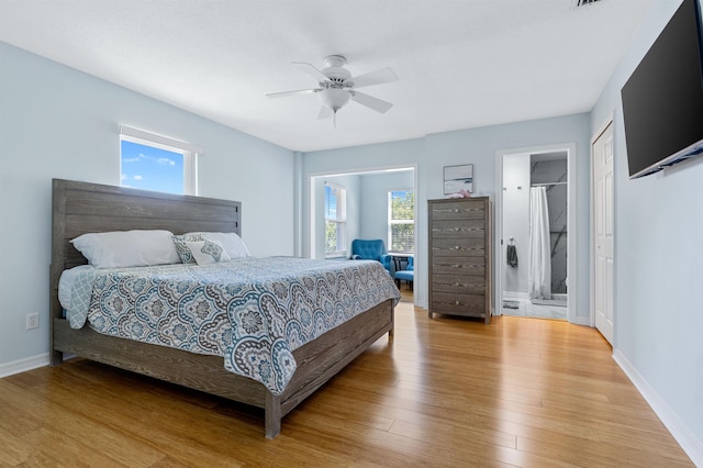 bedroom with ceiling fan, connected bathroom, and light hardwood / wood-style flooring