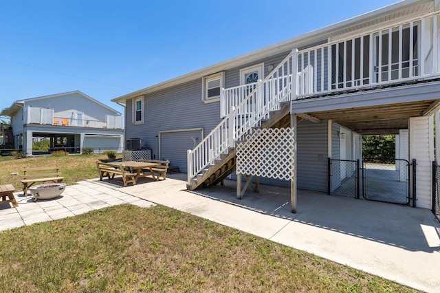 back of house featuring a fire pit, a yard, and a patio