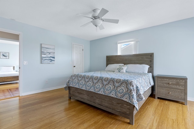 bedroom featuring light hardwood / wood-style floors, ceiling fan, and ensuite bathroom