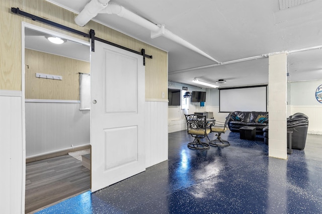 interior space featuring a barn door and wooden walls