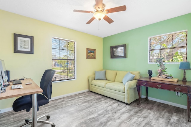 office area with a ceiling fan, baseboards, and wood finished floors