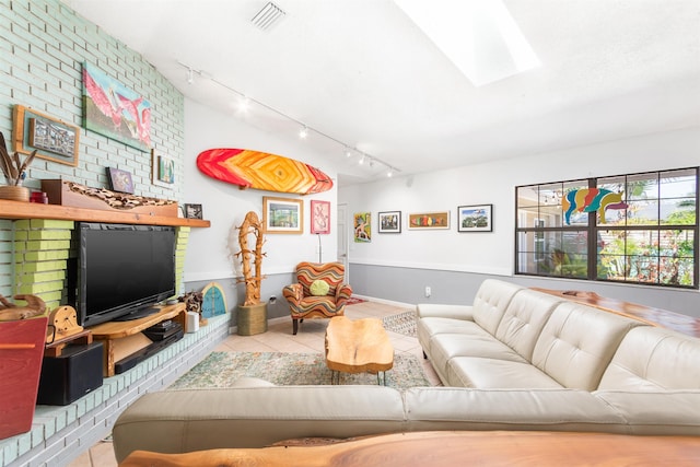 living room featuring a skylight, tile patterned flooring, and visible vents