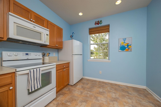 116 Serenity Bay Blvd, Saint Augustine, FL 32080 - kitchen with white appliances, light countertops, brown cabinetry, stone finish flooring, and recessed lighting