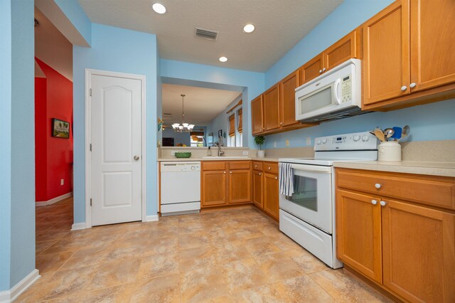 116 Serenity Bay Blvd, Saint Augustine, FL 32080 - kitchen featuring white appliances, a chandelier, light countertops, brown cabinets, and recessed lighting