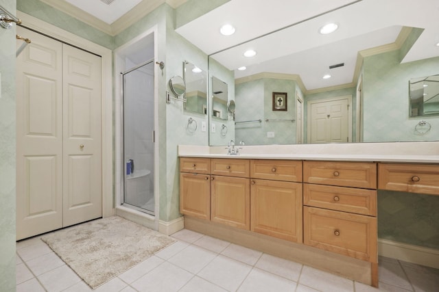 bathroom with vanity, tile patterned floors, a shower with door, and crown molding