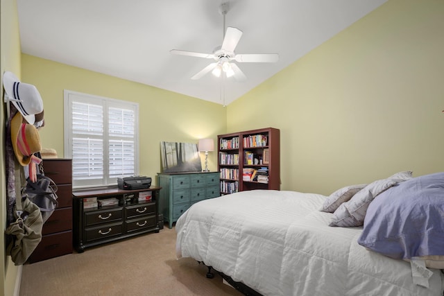 bedroom with light carpet, vaulted ceiling, and a ceiling fan