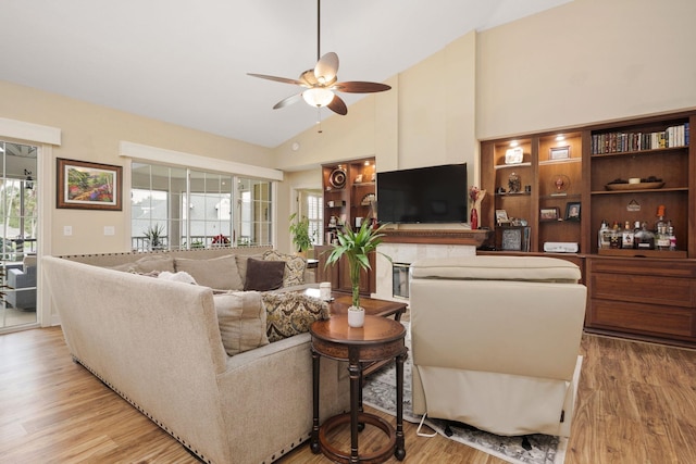 living area with ceiling fan, high vaulted ceiling, and light wood finished floors